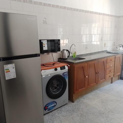 a kitchen with a refrigerator and a washing machine at La Olimareña in Treinta y Tres