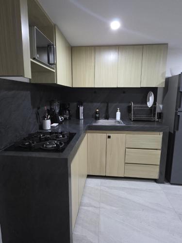 a kitchen with a black counter top and a stove at Departamento frente a bahía con hermosa vista in Acapulco