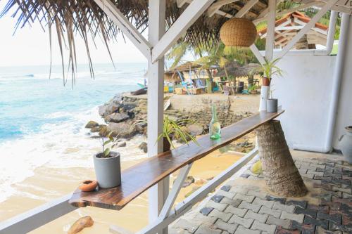 een tafel op het strand met uitzicht op de oceaan bij The Sea Sun villa in Unawatuna