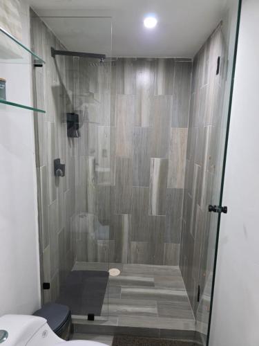 a shower with a glass door in a bathroom at Departamento frente a bahía con hermosa vista in Acapulco