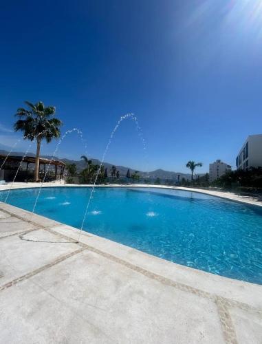 a large swimming pool with a water fountain at Departamento frente a bahía con hermosa vista in Acapulco