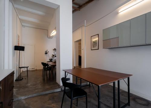 een eetkamer met een houten tafel en stoelen bij The Terraces by Aayu - 2 mins walk to Chulia Street in George Town