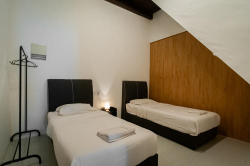 een kamer met twee bedden in een kamer bij The Terraces by Aayu - 2 mins walk to Chulia Street in George Town