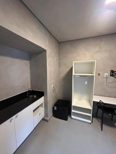 a kitchen with a white refrigerator in a room at #108 Suíte Acolhedora com vaga Centro de Itatiba in Itatiba