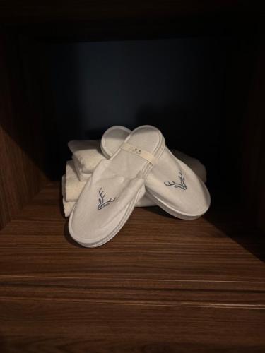 une paire de sandales blanches posées sur un plancher en bois dans l'établissement LyNora Lodge, 