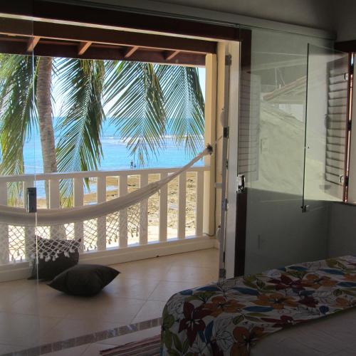 a bedroom with a bed and a view of the ocean at Casa Varandão, 1ª praia, Morro de São Paulo in Cairu