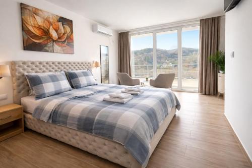 a bedroom with a bed and a large window at Green panorama Vrdnik in Vrdnik