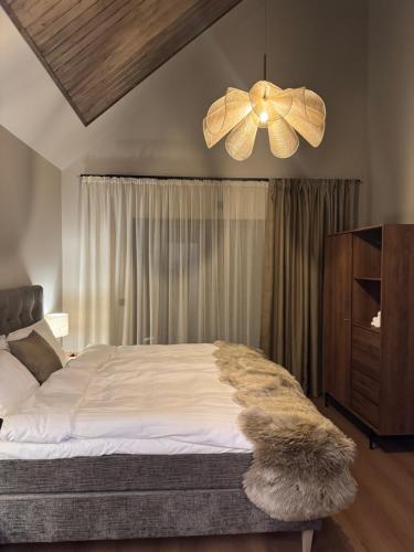 une chambre avec un grand lit et un lustre dans l'établissement LyNora Lodge, 