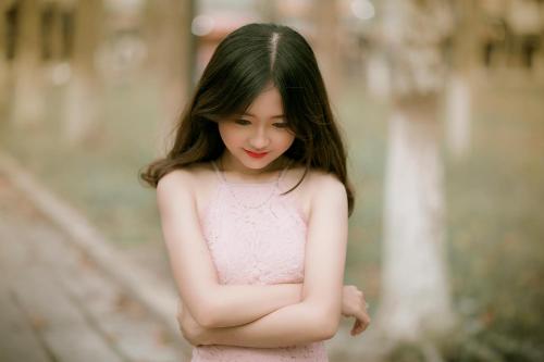a young woman in a pink dress with her arms crossed at HUB KAMi in Cikunir Satu