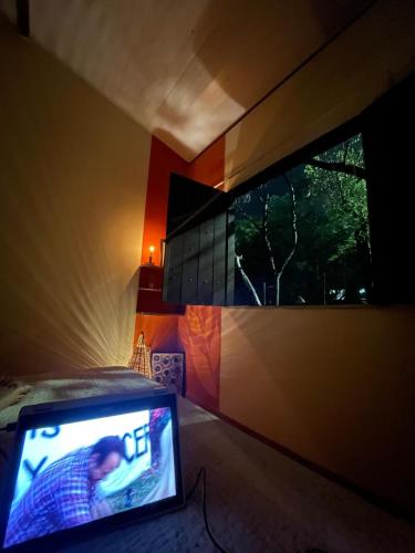 a bedroom with a tv and a large window at Casa Kahlo in Lençóis