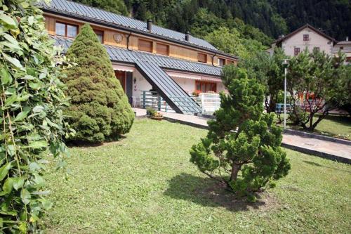 twee bomen in een tuin voor een gebouw bij Casa Per Ferie Arta Terme in Arta Terme