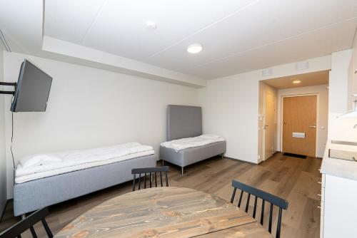una stanza con due letti, un tavolo e delle sedie di Cozy apartment for three by the ski trails a Sotkamo