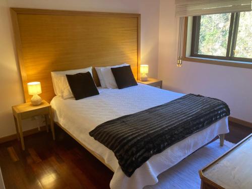 a bedroom with a large bed with two lamps at Residência Albuquerque in Santa Maria Da Feira