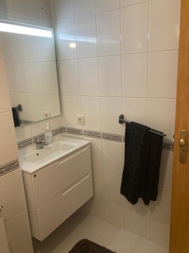 a white bathroom with a sink and a mirror at Residência Albuquerque in Santa Maria Da Feira