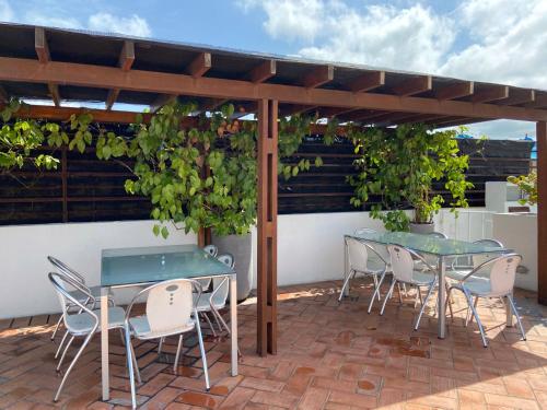 een patio met 2 tafels en stoelen onder een pergola bij Virrey Luxury Aparments in Ciudad Amurallada in Cartagena