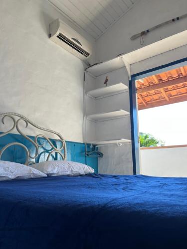 ein Schlafzimmer mit einem blauen Bett und einem Fenster in der Unterkunft Janaína Picinguaba in Ubatuba