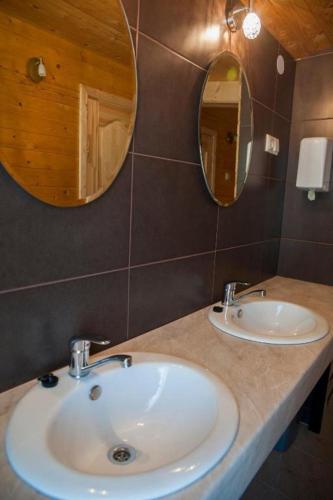 a bathroom with two sinks and two mirrors on a counter at Zelta Ābols in Ventspils