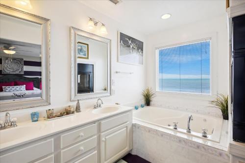 a bathroom with two sinks and a tub and a large mirror at SS3 - Bella Luna in Southern Shores