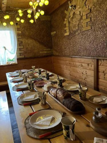 een lange tafel met borden en bestek erop bij Zelta Ābols in Ventspils