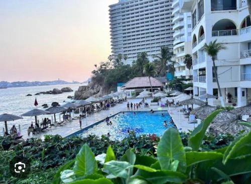 a resort with a swimming pool next to the ocean at Torres Gemelas Costera MA con Playa Privada in Acapulco