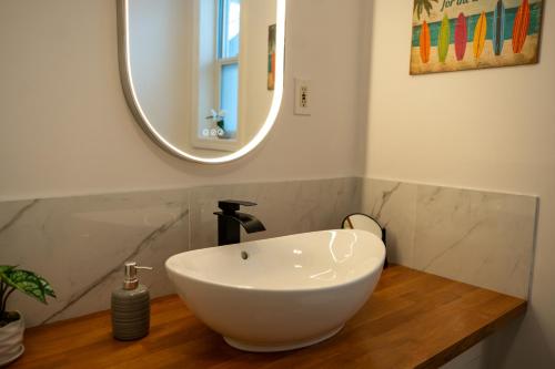 a bathroom with a white sink and a mirror at Rare Cozy Home near Downtown WPG - Free Parking in Winnipeg