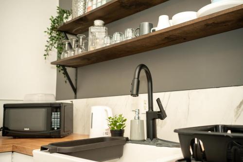 a kitchen counter with a sink and a microwave at Rare Cozy Home near Downtown WPG - Free Parking in Winnipeg