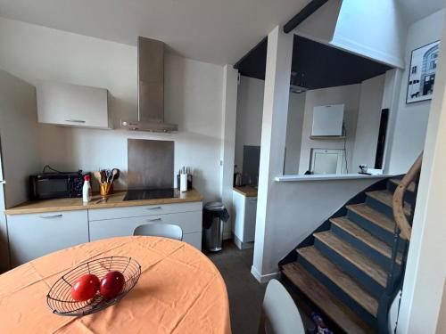 une cuisine avec une table et des tomates dans un bol dans l'établissement Gîte 1908 avec GARAGE, à Wimereux