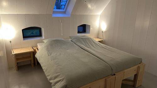 een groot bed in een kamer met twee tafels bij Benbijdokkum in Driesum