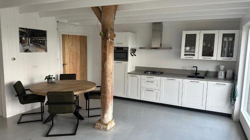 een keuken met een tafel en stoelen in een kamer bij Benbijdokkum in Driesum