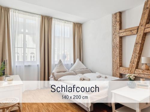 een witte slaapkamer met een bed en een raam bij Albert & Viktoria Loft mit Parkplätzen in Coburg