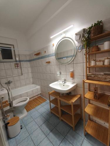 un bagno con lavandino, WC e specchio di Dn'A home by the lake a Anatolí