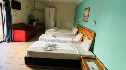 una camera con due letti e un divano rosso di Quad Studio 2936 a San Pawl il-Baħar