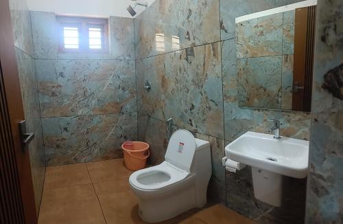 ein Badezimmer mit Toilette und Waschbecken in der Unterkunft Sandora Home Stay in Varkala