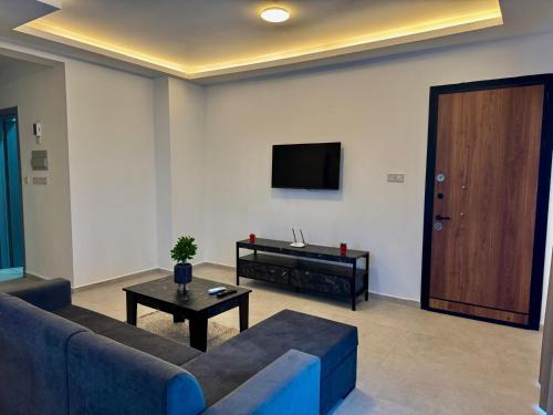 een woonkamer met een bank, een tv en een tafel bij Soğular Apartments 1 in Aglantzia