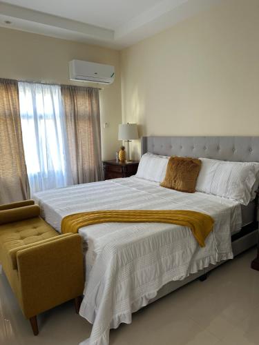 een slaapkamer met een groot bed en een raam bij Serenity Villa in Ocho Rios