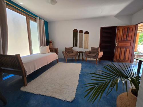 a bedroom with a bed and a table and chairs at Casa Ébano Brasileiro in Porto Seguro