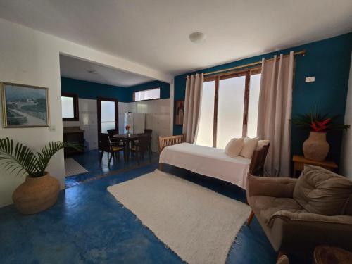 a bedroom with a bed and a couch and a table at Casa Ébano Brasileiro in Porto Seguro