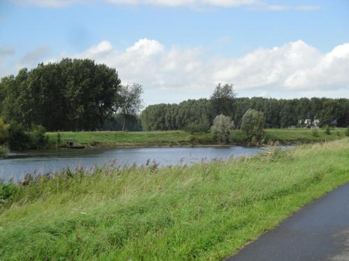 a river next to a road next to a field at B&B De Zoete Kers in Wakken
