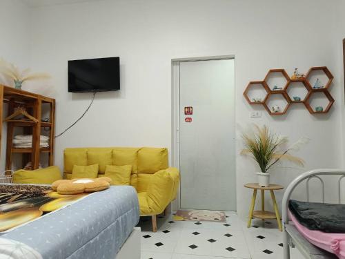 un soggiorno con un divano giallo e una TV di มินิฮาร์ท เฮาส์บีช Mini Heart House Beach a Ban Chak Phai