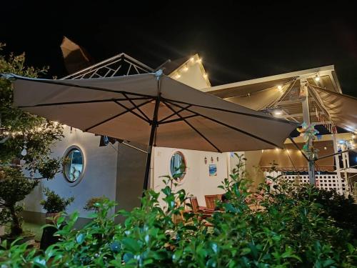 einen Regenschirm vor einem Haus in der Nacht in der Unterkunft มินิฮาร์ท เฮาส์บีช Mini Heart House Beach in Ban Chak Phai