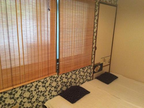 a small room with two beds and a window at Hanakiya in Kyoto