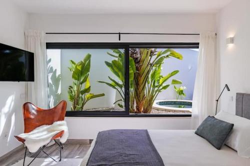 a bedroom with a large window and a bed and a chair at Amazing Views Villa in Loulé