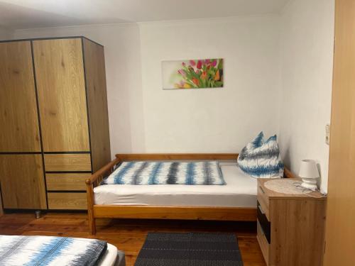 een slaapkamer met een bed en een houten kast bij Landhaus Ganzer in Niedernsill