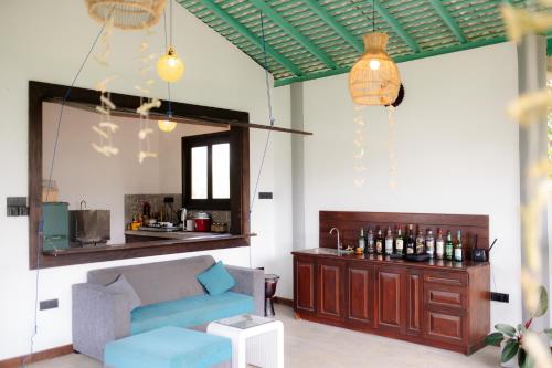 un salon avec un canapé bleu et un bar dans l'établissement Black Lantern, à Matara