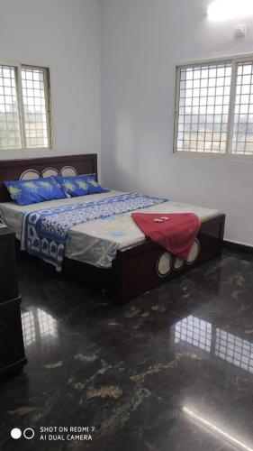 a bedroom with a bed with a red pillow on it at Peacock Abode Farm in Bangalore