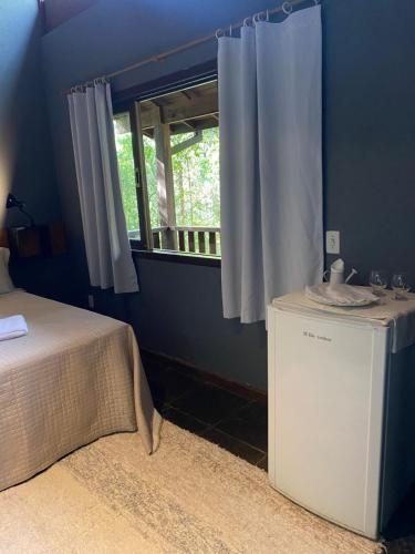 a blue room with a bed and a window at Havilá Arara Azul in Nova Friburgo