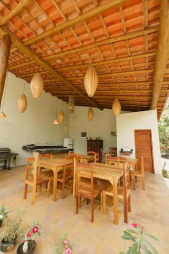 a dining room with wooden tables and chairs at Jardim do Wape in Santa Cruz Cabrália