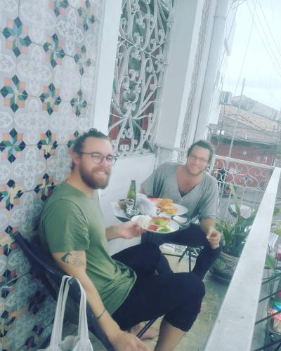 Due uomini seduti a un tavolo con un piatto di cibo di Epoca Iquitos a Iquitos