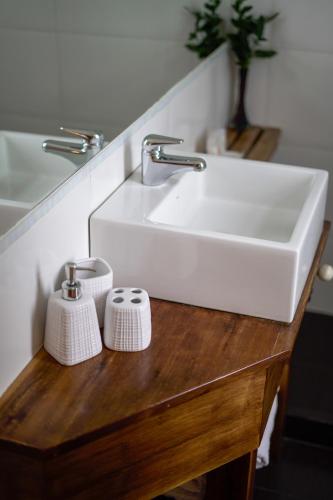 a white sink on a wooden table in a bathroom at Los Muelles Boutique Hotel in Carmelo
