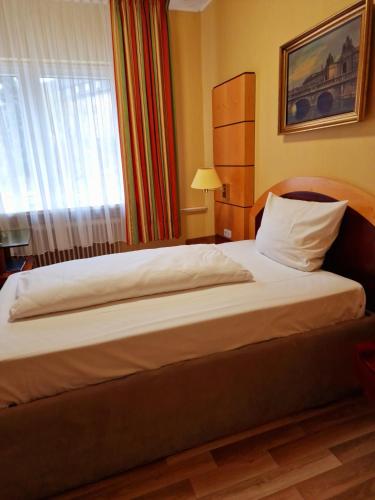 a large bed in a hotel room with a window at Pension Pale' Bach in Bad Hersfeld